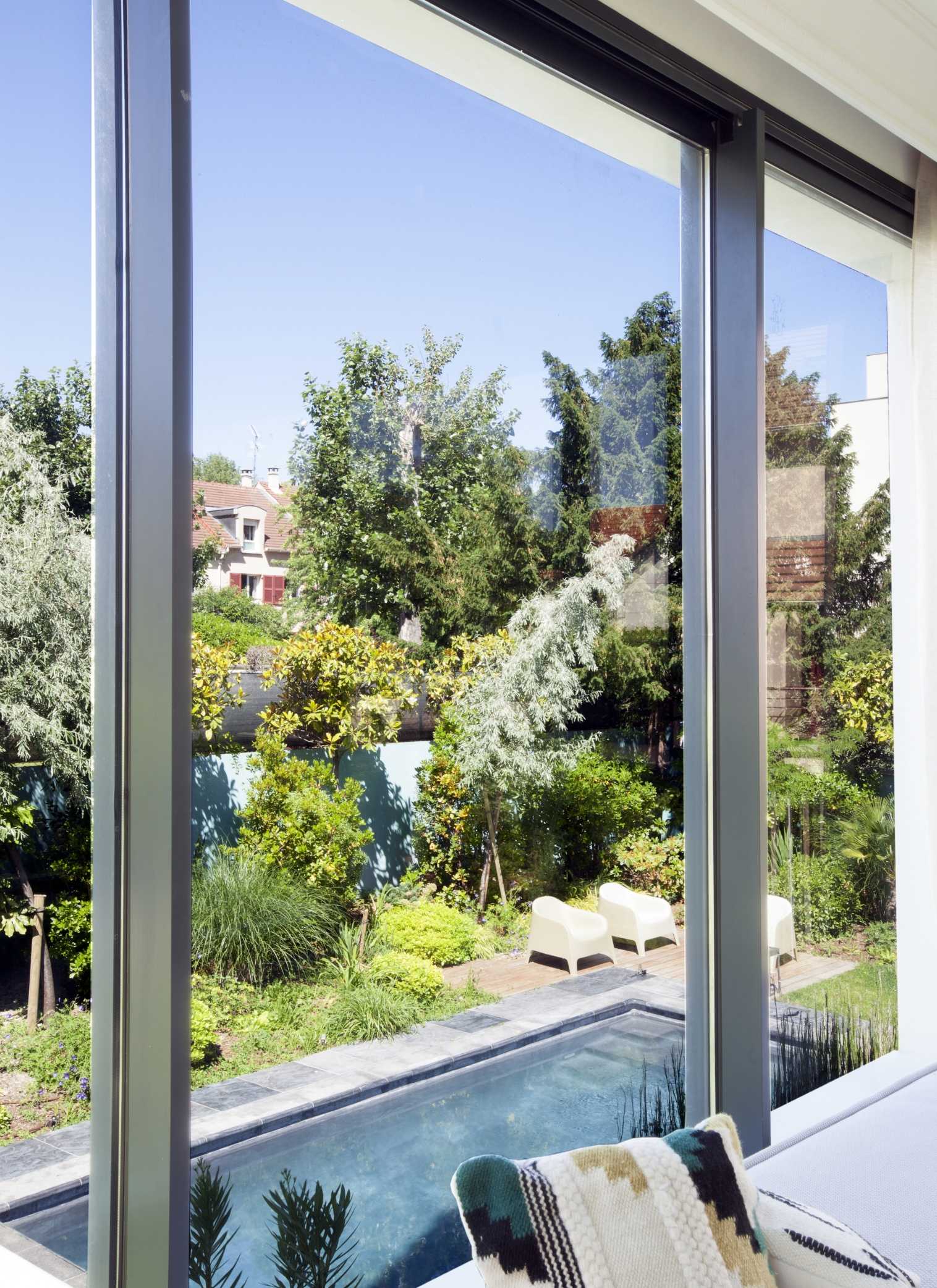 Jardin avec piscine d'une maison en meulières aménagée par un paysagiste en région parisienne